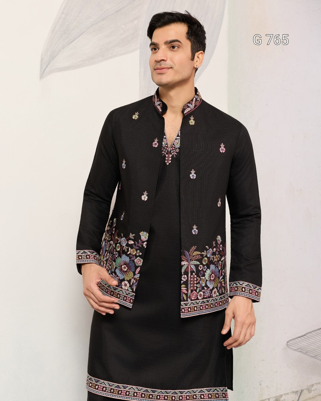 Man wearing a black embroidered kurta with a white background