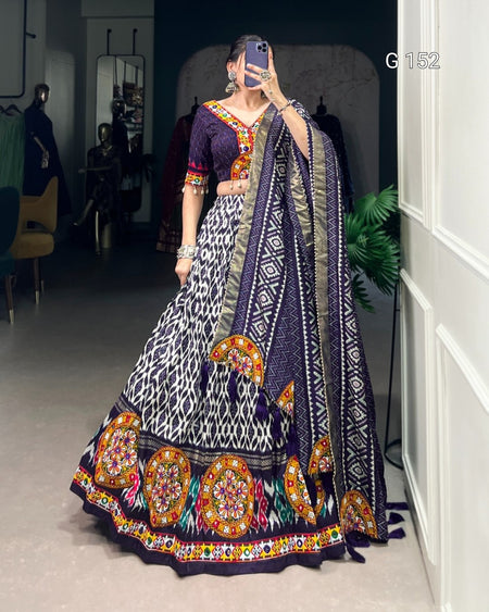 Woman in a traditional outfit with intricate patterns taking a selfie.