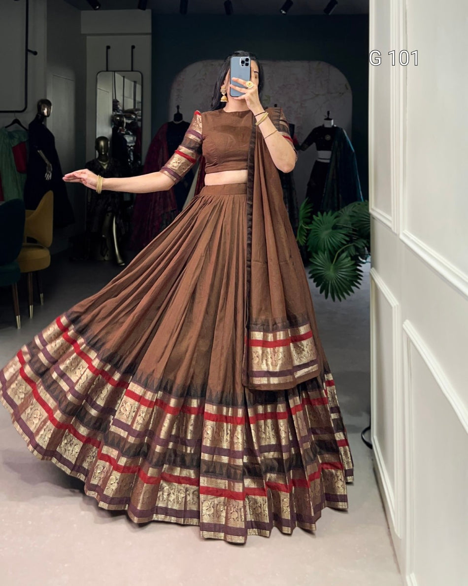 Woman wearing a brown and red plaid dress in a room with mirrors and plants.