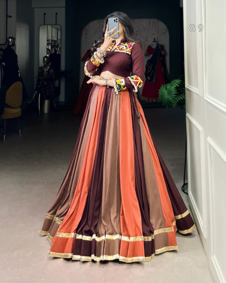 Person wearing a long, multicolored dress with floral accessories in a room.