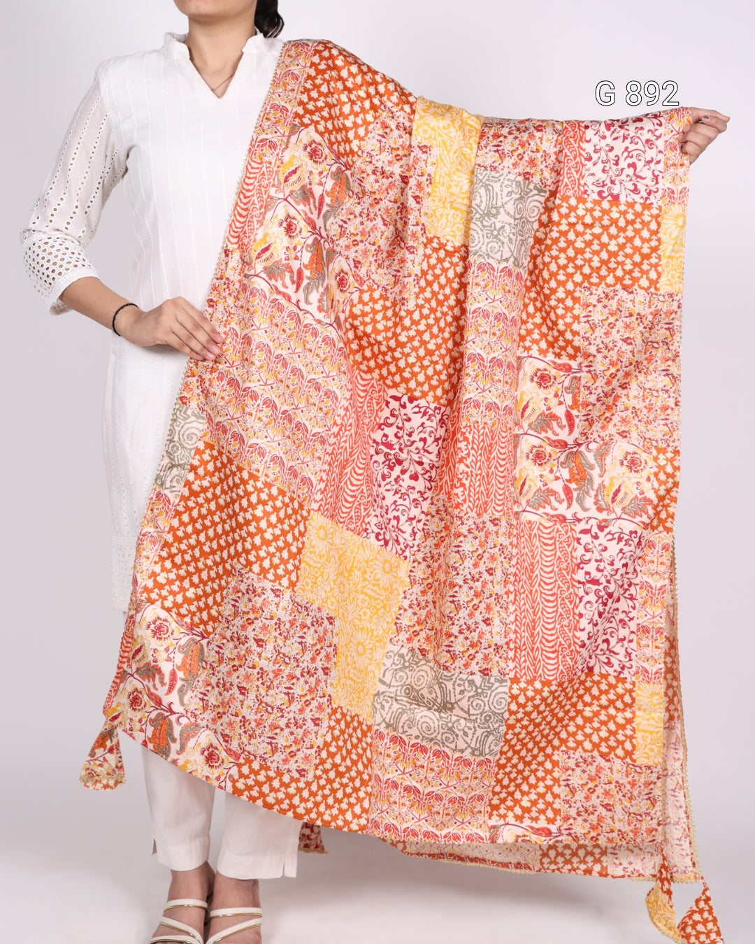 Person holding a colorful patterned scarf against a white background