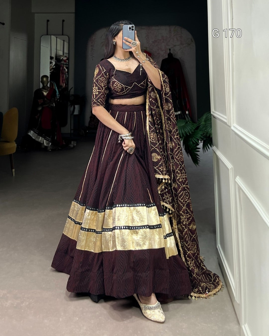 Woman in a traditional outfit with a long skirt and top, standing in a room.