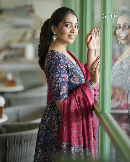 Woman in a blue and pink traditional outfit standing indoors.