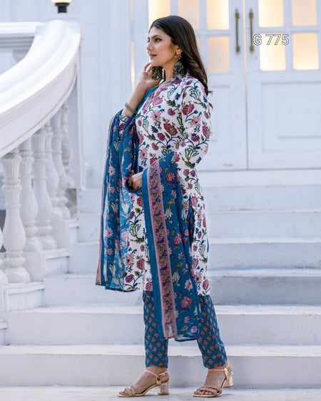 Woman in a floral and blue outfit standing on white steps.