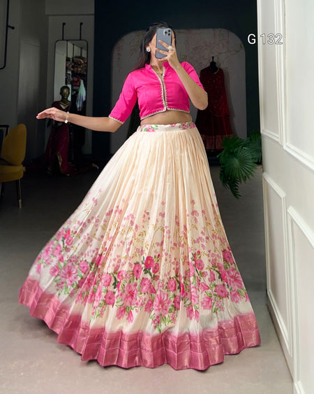 Woman wearing a pink blouse and floral skirt in a room.