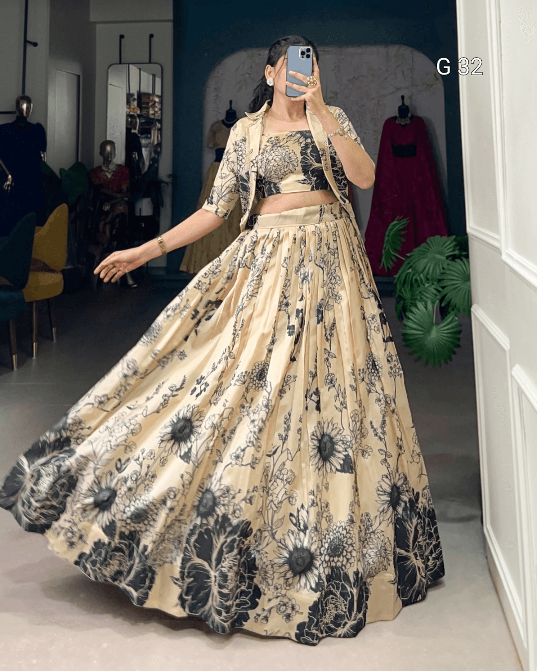 Woman wearing a floral outfit taking a mirror selfie in a room.