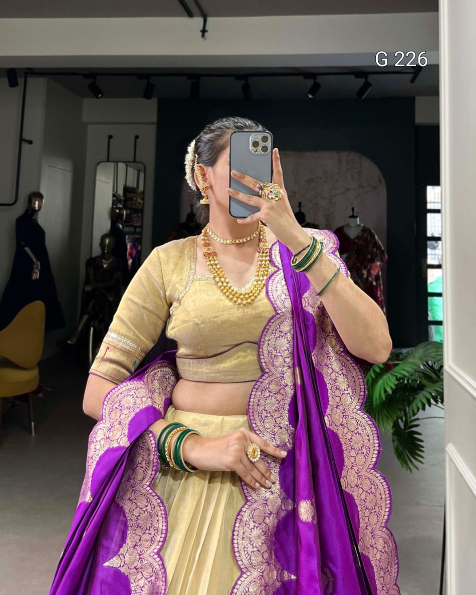Woman in a traditional outfit with a purple saree and gold blouse, taking a mirror selfie.