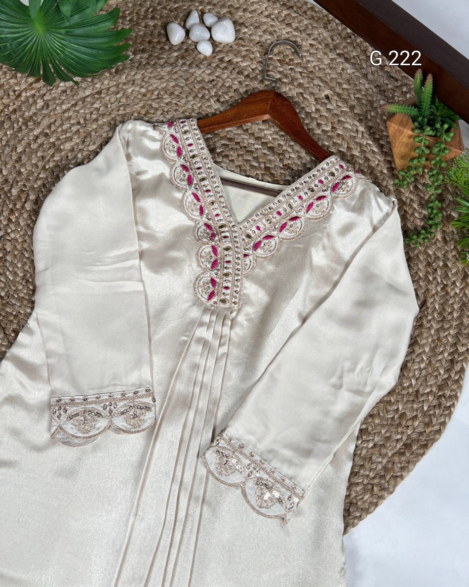 White embroidered blouse on a wooden hanger with a textured surface background