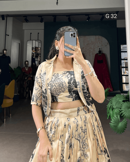 Woman taking a mirror selfie wearing a floral outfit in a store setting.