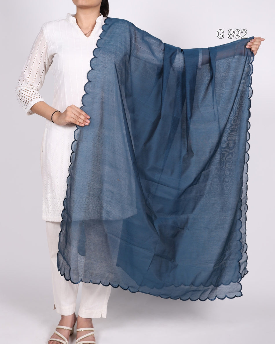 Person holding a blue scarf with scalloped edges on a white background