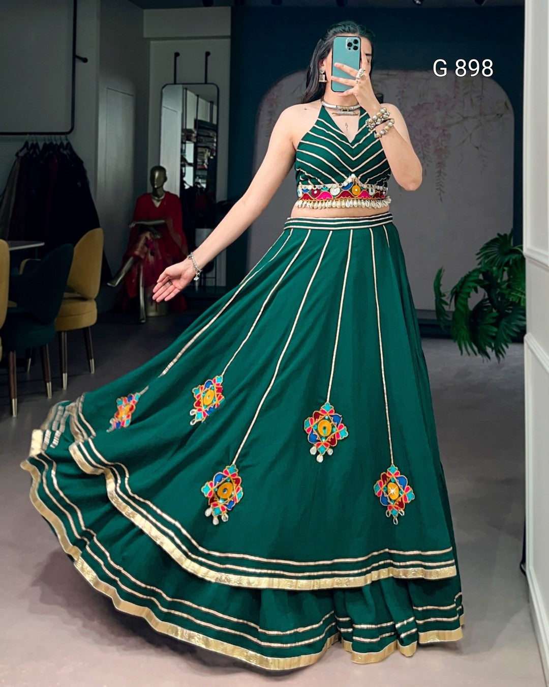 Woman wearing a green embroidered dress in an indoor setting.