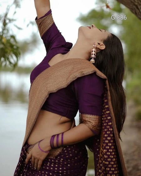 Woman in a purple traditional outfit with a beige shawl against a blurred natural background