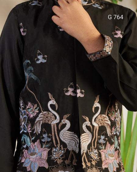 Black garment with intricate embroidery of birds and flowers, brand 'G 764' visible.