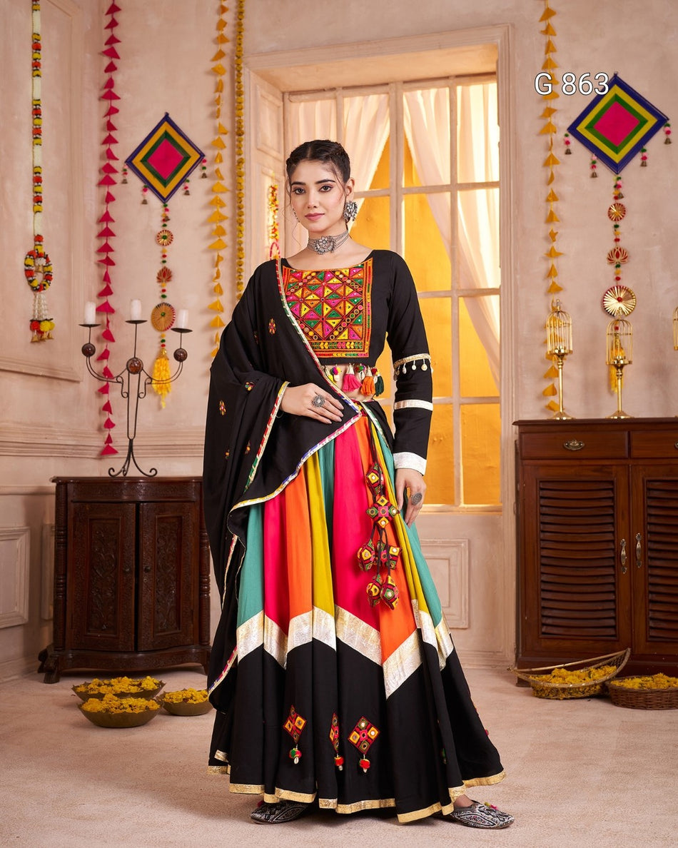 Woman in a colorful traditional outfit with geometric patterns in a decorated room.