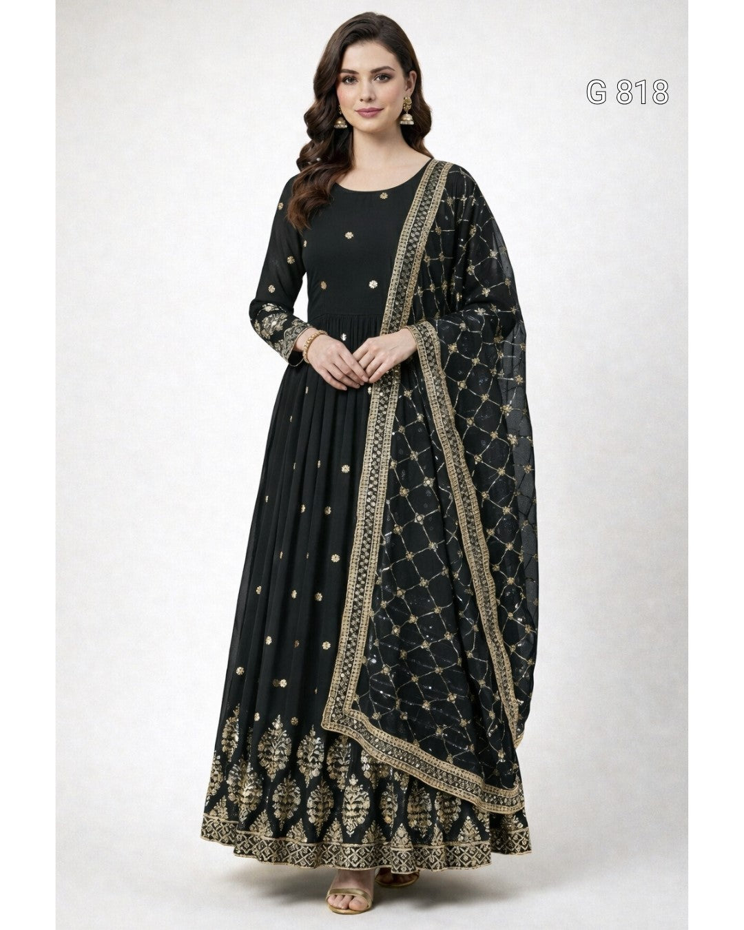 A woman modeling a black floor-length Anarkali gown with gold embroidery and a matching printed dupatta, shown against a plain light gray studio background.