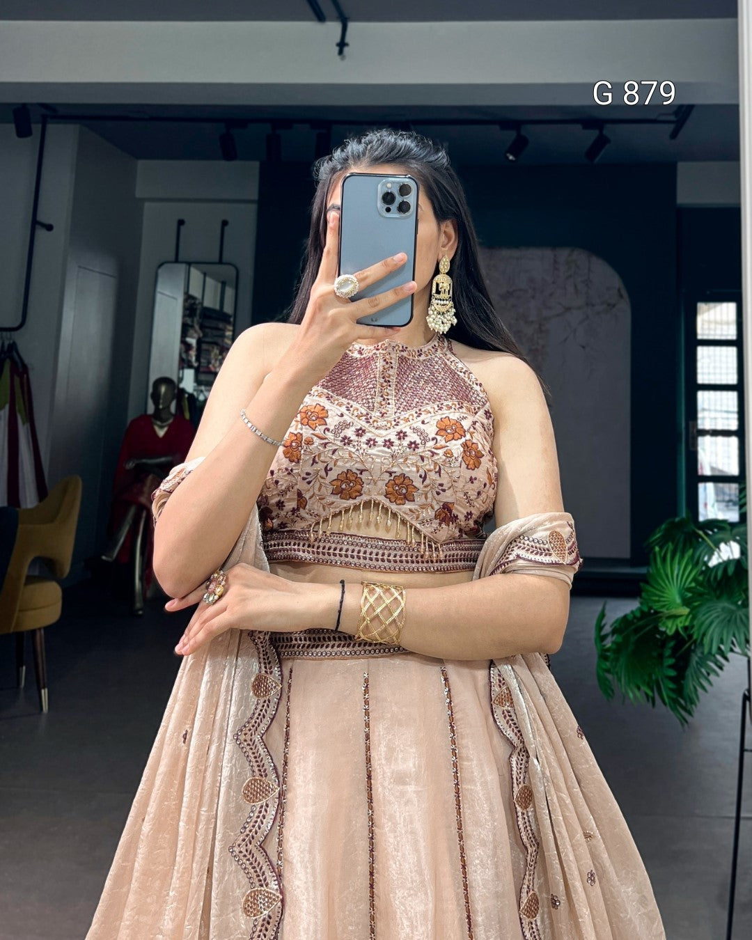 Woman taking a mirror selfie wearing an embroidered traditional outfit in a room.