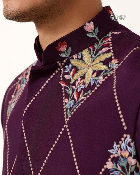 Close-up of a purple embroidered shirt with floral patterns on a white background