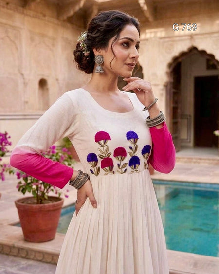 Woman in a white dress with floral embroidery in an outdoor setting
