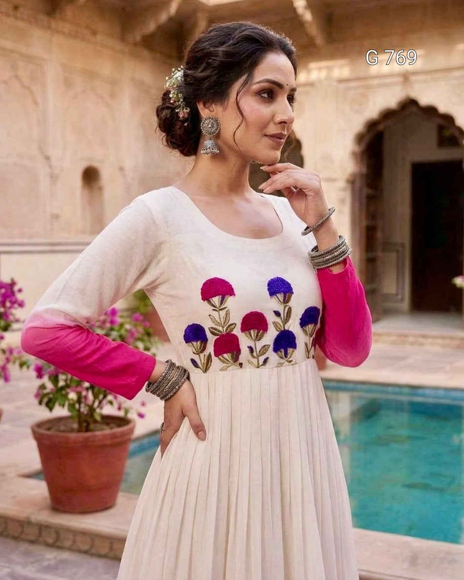 Woman in a white dress with floral embroidery in an outdoor setting