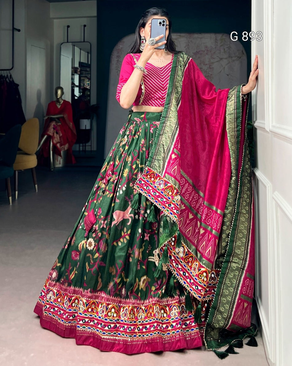 Woman wearing a traditional green and pink lehenga with a mirror reflection in the background.