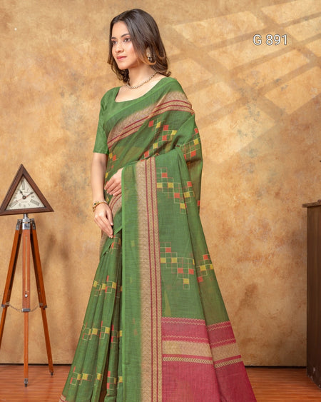 Woman wearing a green saree with a patterned border against a brown background