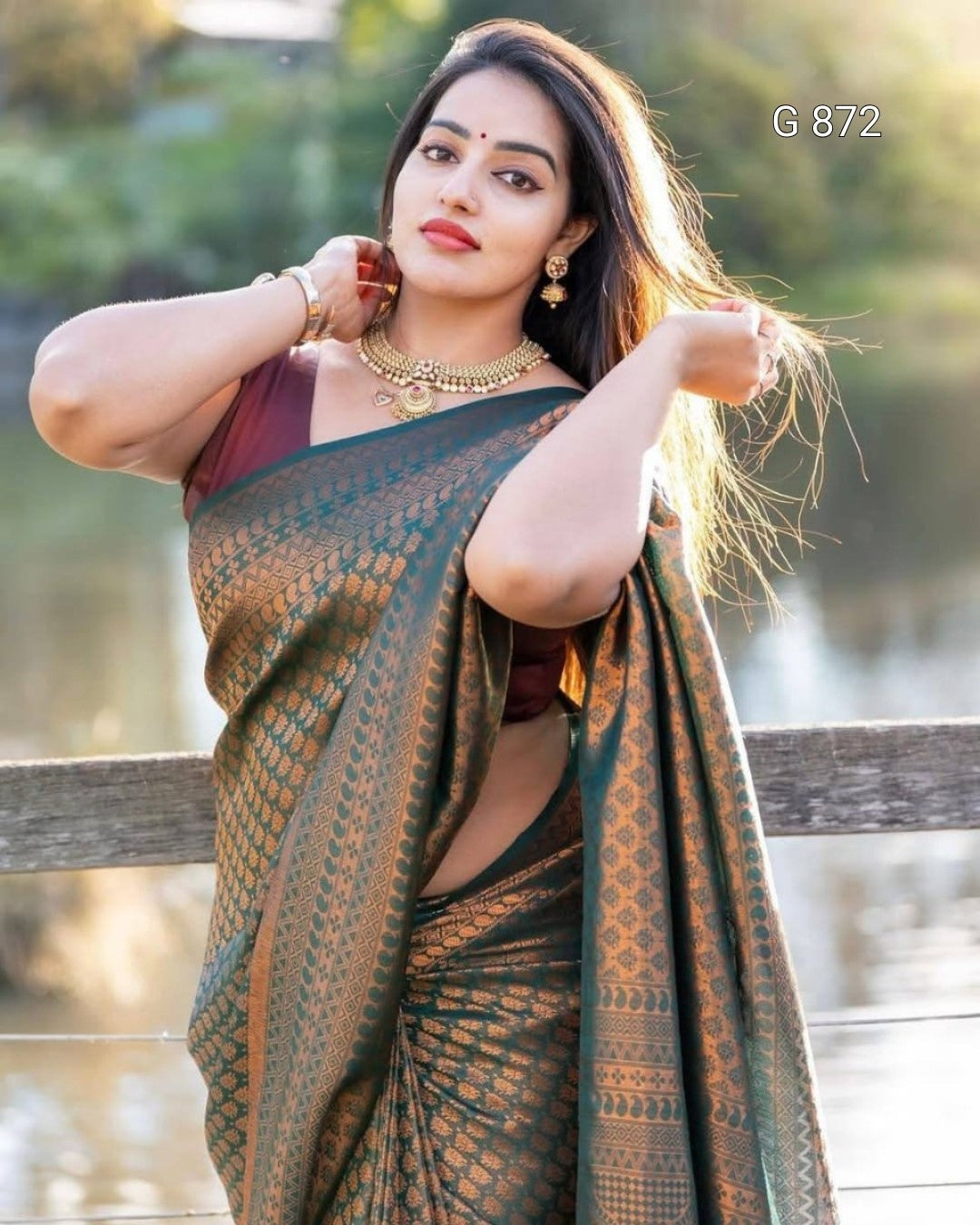 Woman in a green saree with a blurred natural background