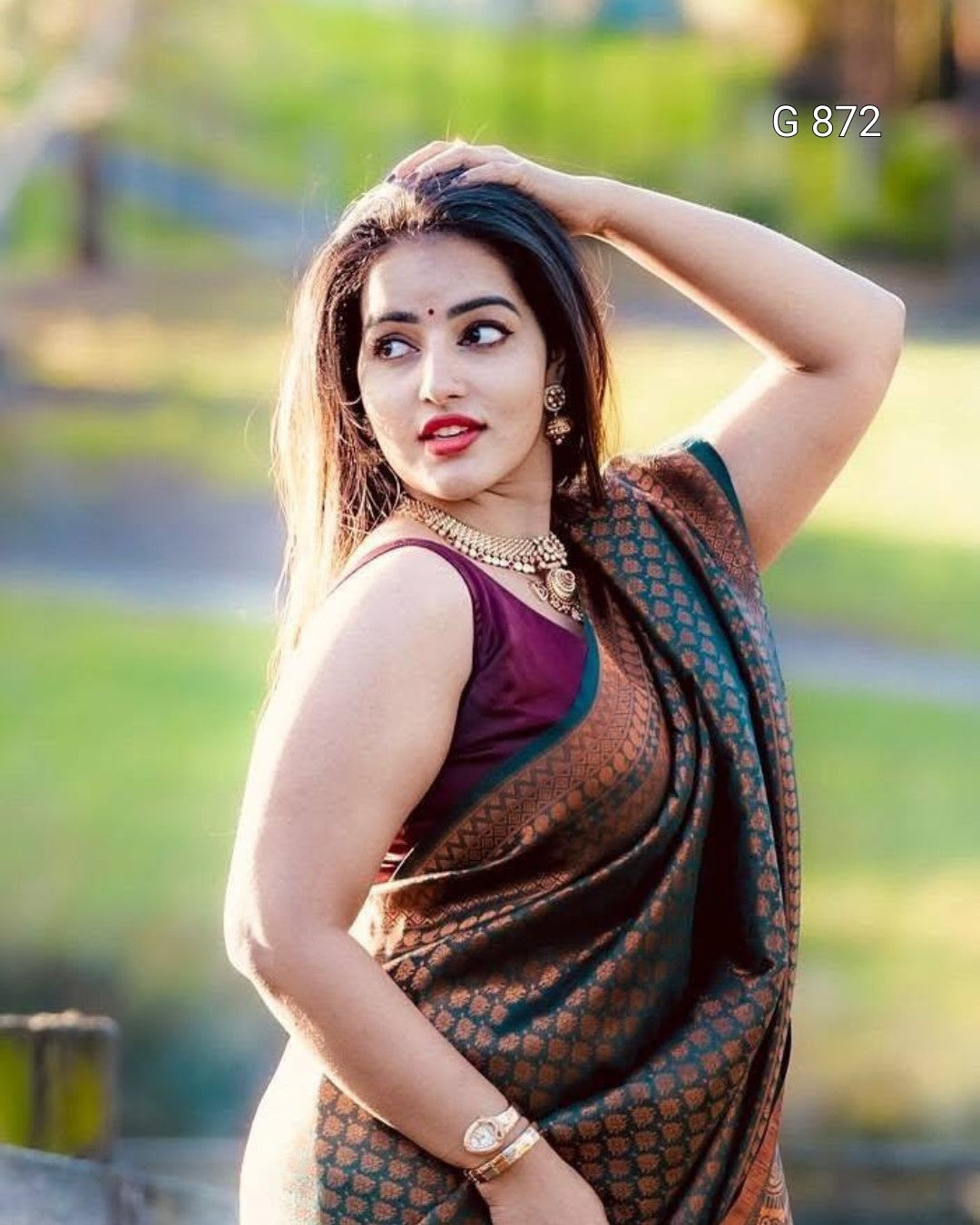 Woman in traditional attire with a blurred green outdoor background
