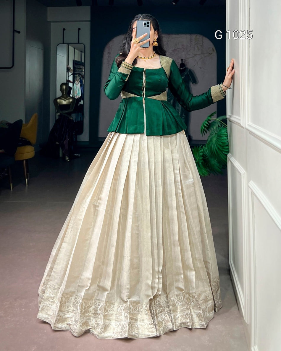 A woman takes a mirror selfie wearing a traditional Indian outfit with a dark green velvet peplum top and a voluminous cream-colored flared skirt. The setting appears to be a boutique or fitting room with a white paneled door on the right.