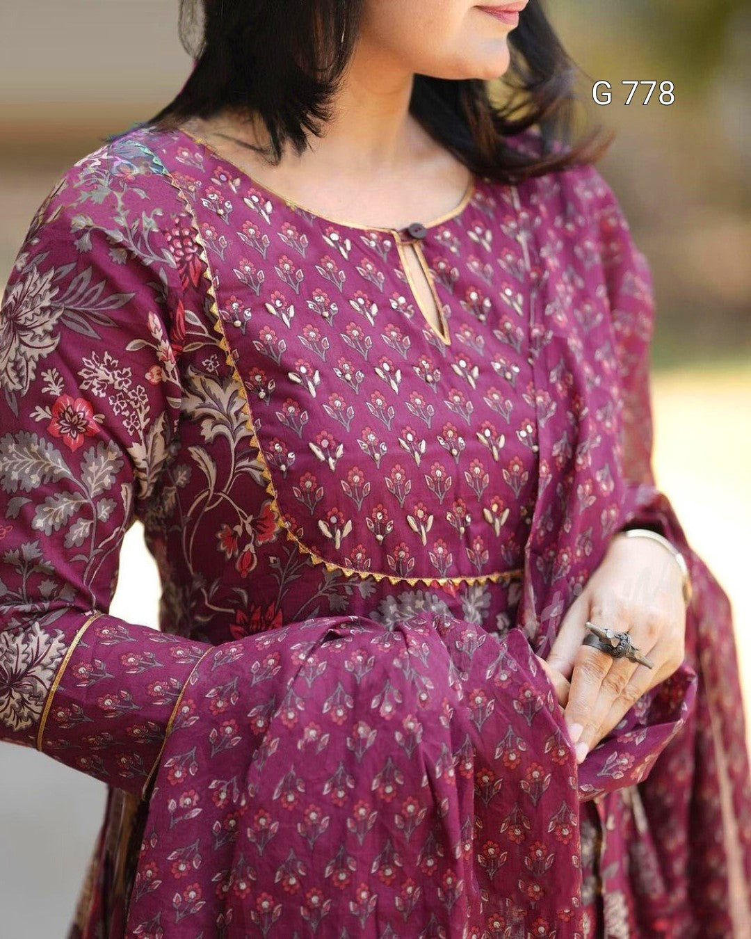 Woman wearing a purple patterned dress with a blurred background