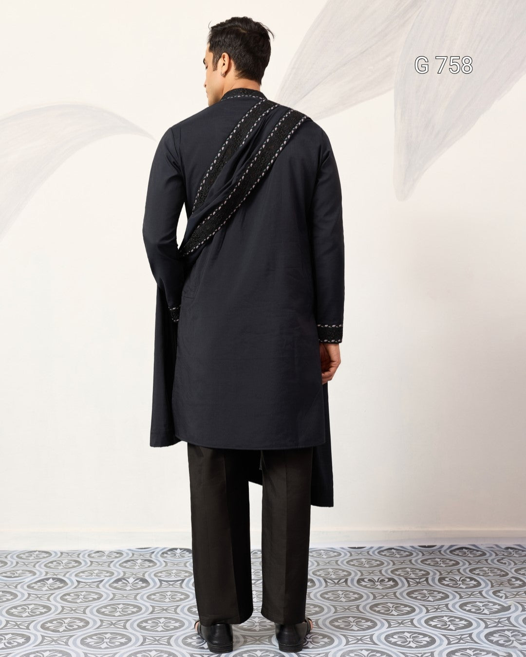 Man wearing a navy blue traditional outfit with a white background