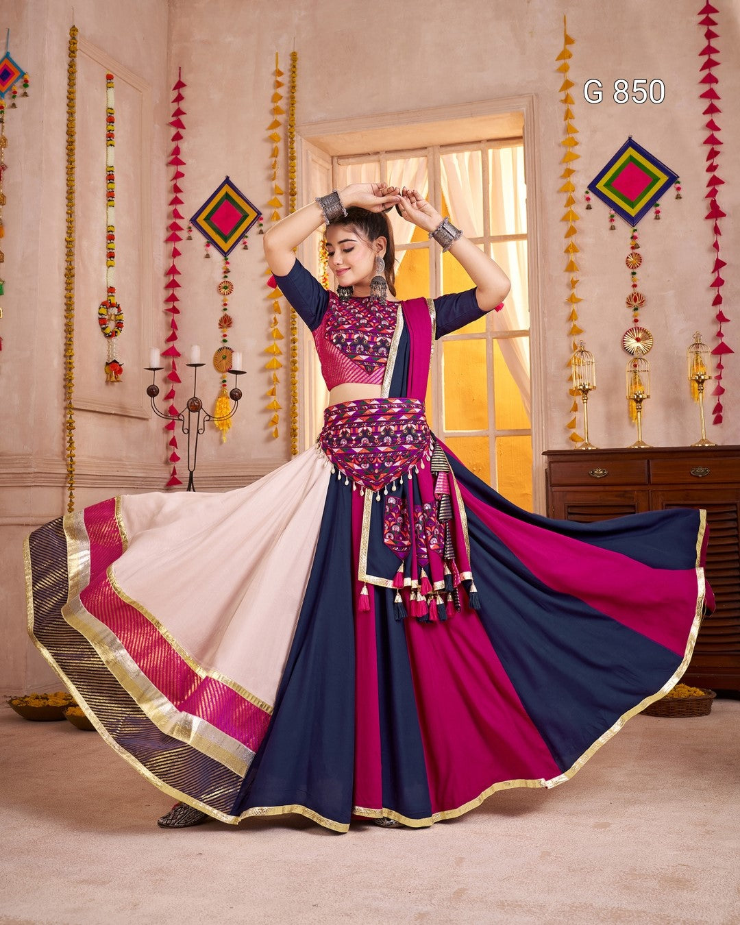 Woman in a traditional outfit with a colorful saree in a decorated room.