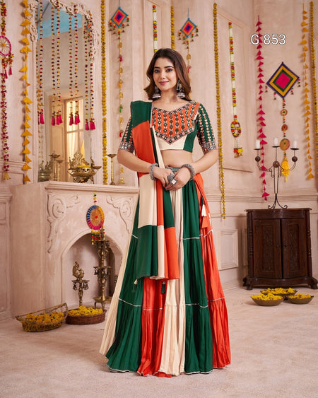 Woman in a colorful traditional outfit standing in a decorated room.