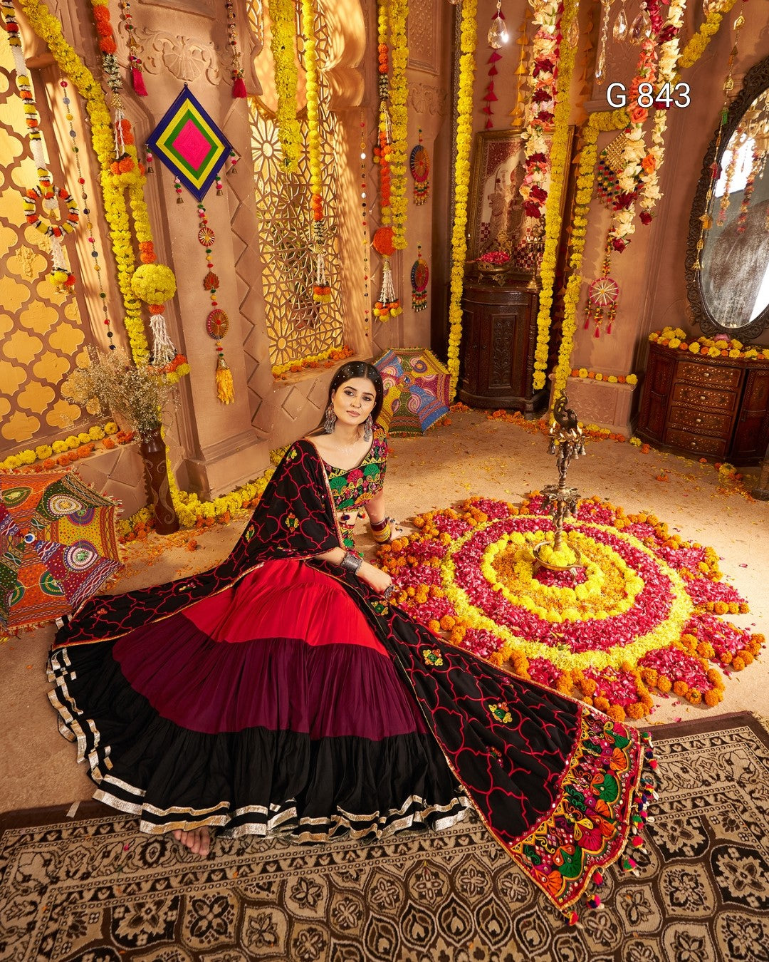 Woman in traditional attire sitting on a decorated floor with floral patterns