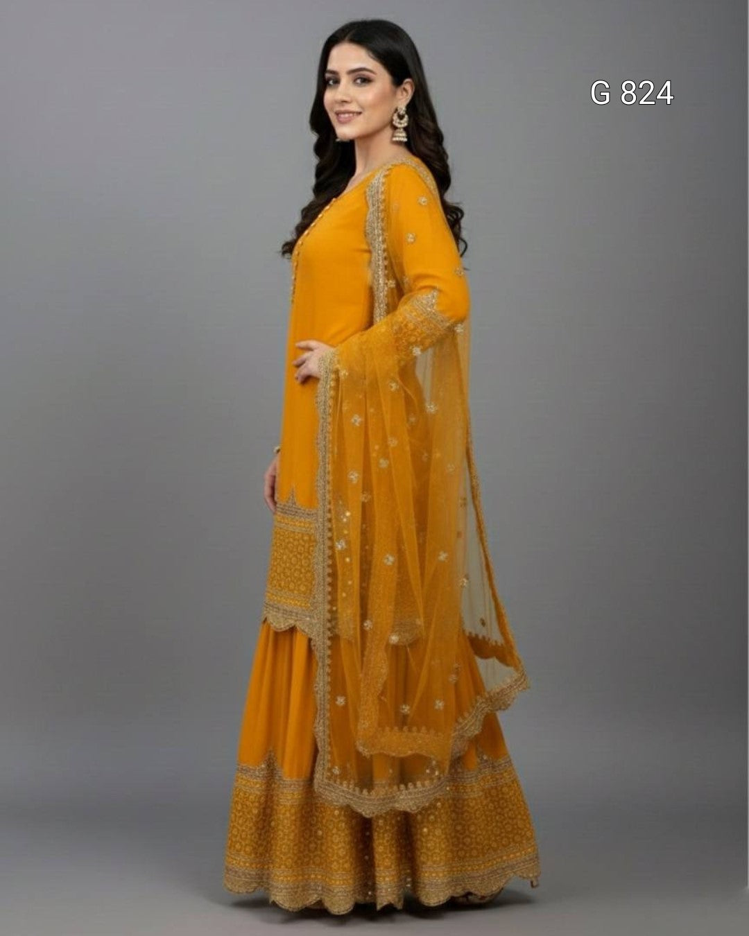 Woman wearing a mustard yellow traditional outfit with gold embroidery on a gray background