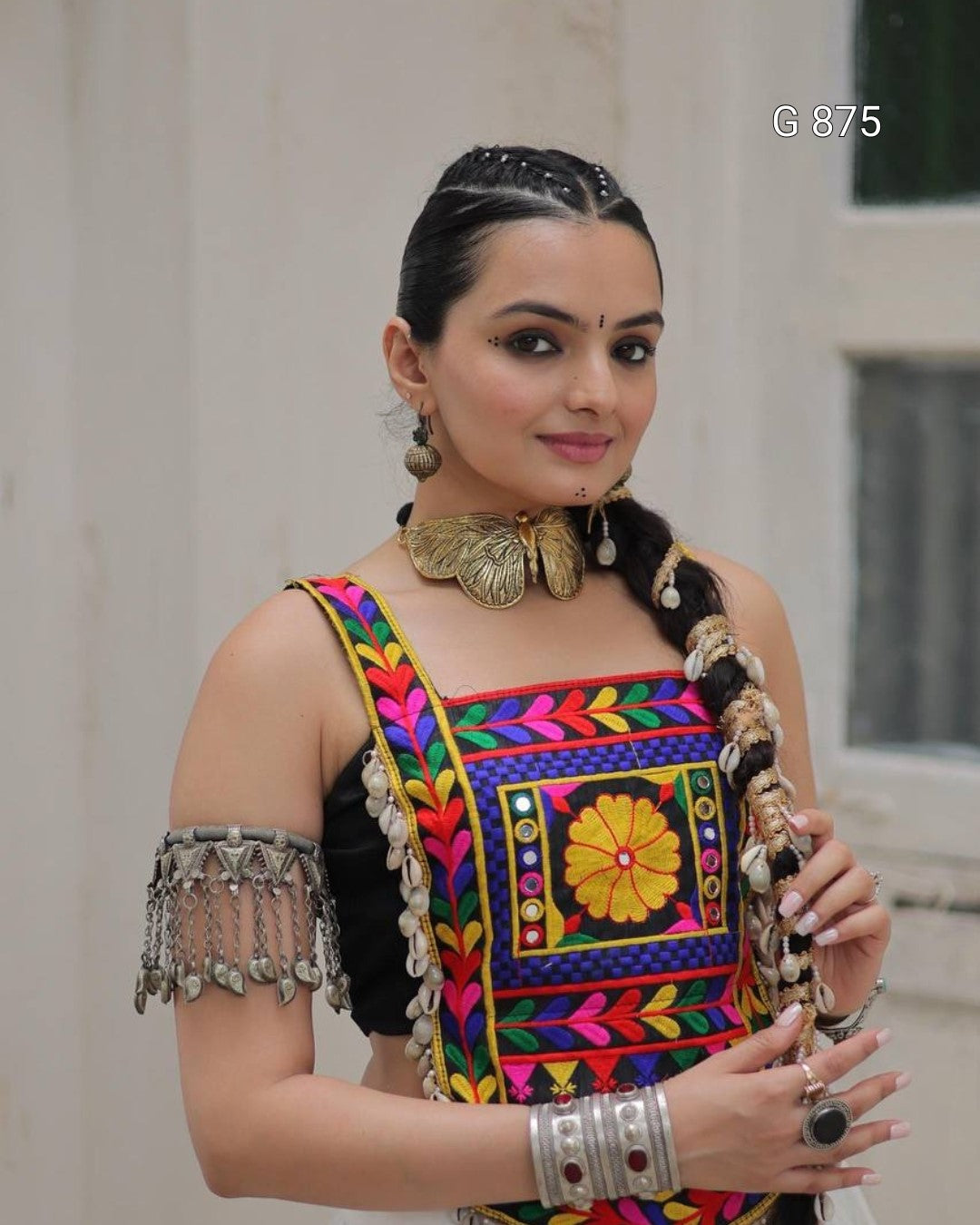 Woman wearing a colorful traditional outfit with intricate designs.