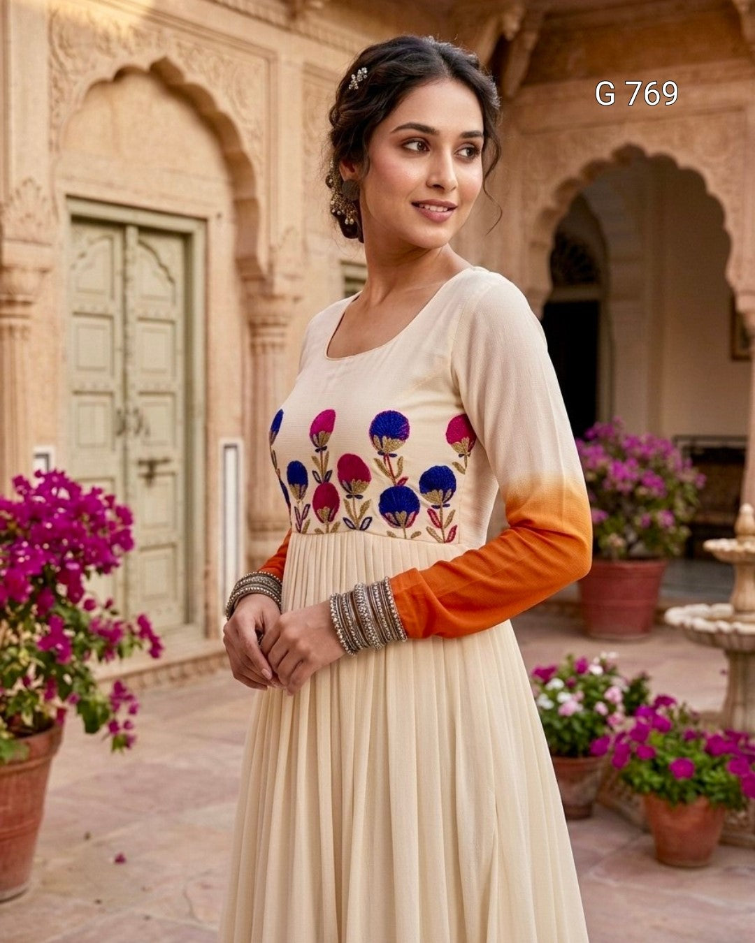 Woman wearing a cream-colored dress with colorful floral patterns in an outdoor setting.