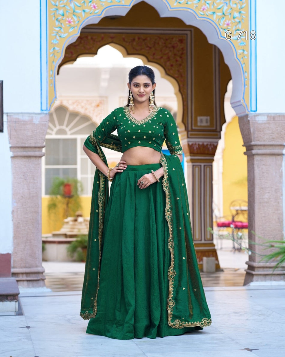 Woman in a green traditional outfit standing in front of an ornate archway.