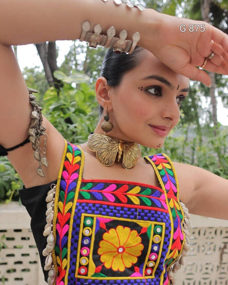 Woman wearing a colorful traditional outfit with intricate designs and jewelry.