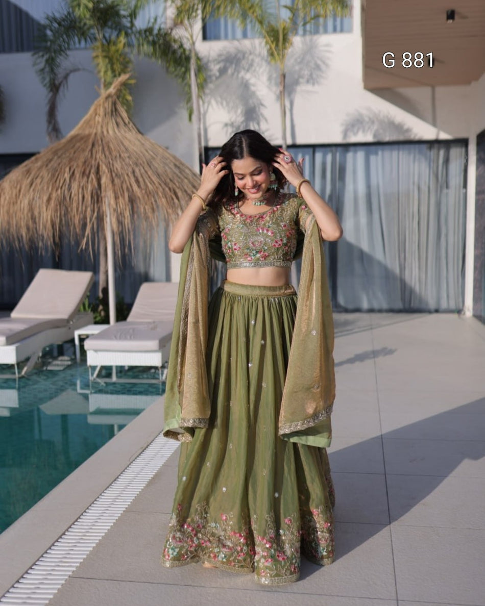 Woman in a green traditional outfit standing by a poolside.