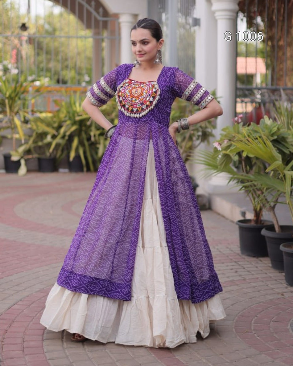 A woman modeling a traditional Indian outfit featuring a purple embroidered anarkali-style dress with a sheer embroidered overlay and a cream-colored skirt, set in an outdoor patio environment with potted plants.