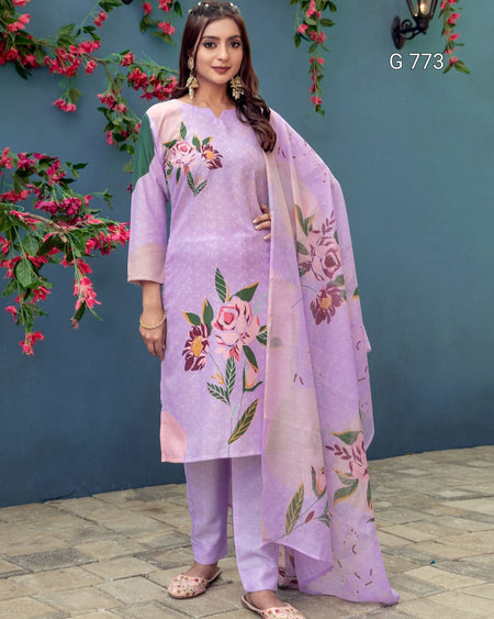 Woman wearing a lavender outfit with floral patterns against a blue wall with pink flowers.