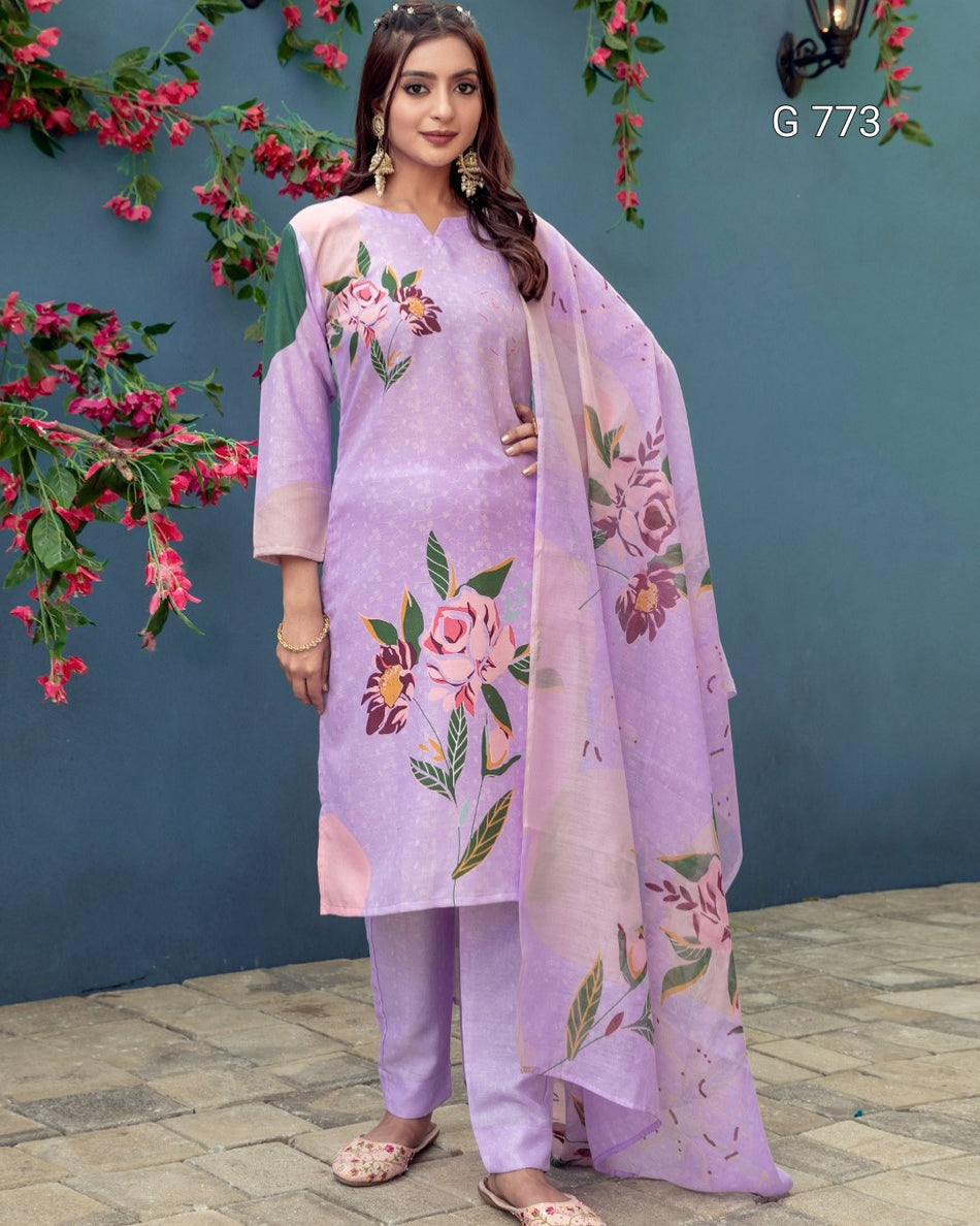 Woman wearing a lavender outfit with floral patterns against a blue wall with pink flowers.