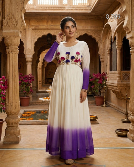 Woman in a white and purple dress with floral embellishments in an ornate indoor setting.