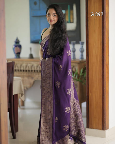Woman wearing a purple saree with a pattern in a room setting