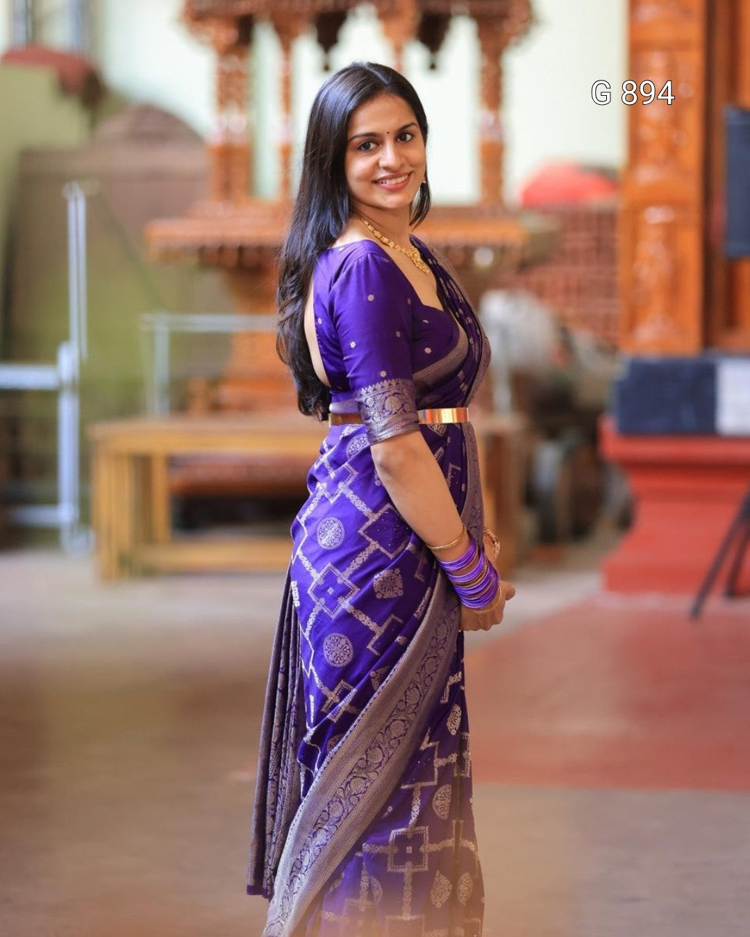 Woman in a purple saree with a blurred background