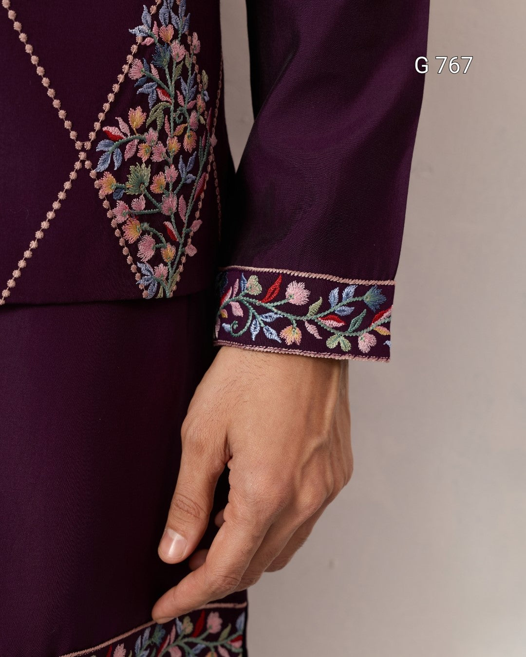 Close-up of a purple garment with intricate floral embroidery on a plain background