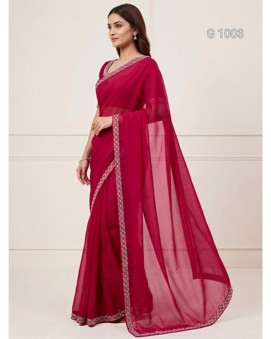 A woman modeling a deep magenta pink saree with silver border embroidery, standing against a light beige wall. The text 'G 1003' is visible in the top right corner.