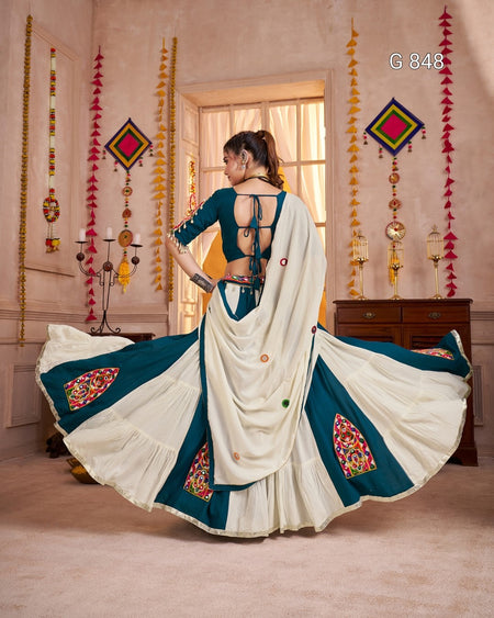 Woman in a traditional saree with decorative elements in a decorated room.