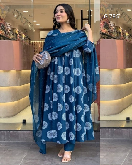 Woman wearing a blue patterned outfit with a matching shawl in a store setting.