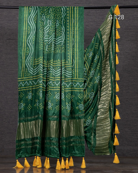 Green saree with yellow patterns and tassels on a dark background